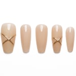 Long nude coffin press-on nails with minimalist gold X accent design and glossy finish