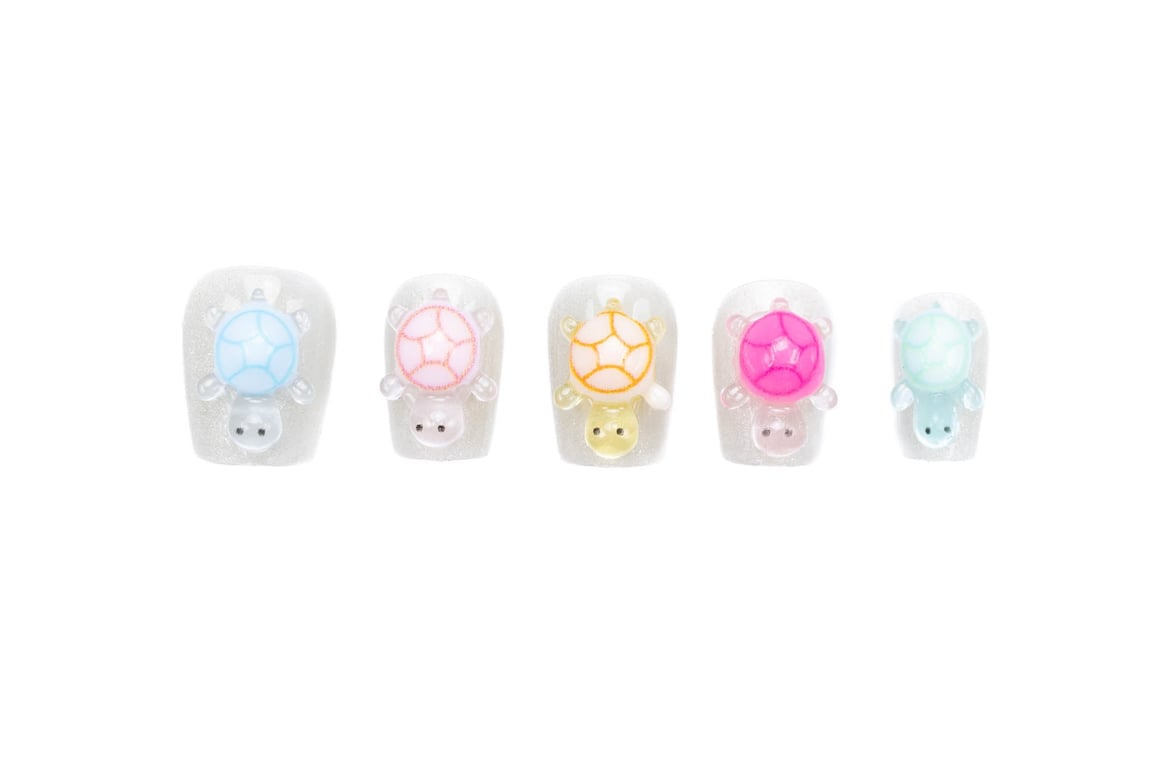 Short squoval press-on nails featuring 3D pastel turtles on shimmering white base, perfect for everyday wear