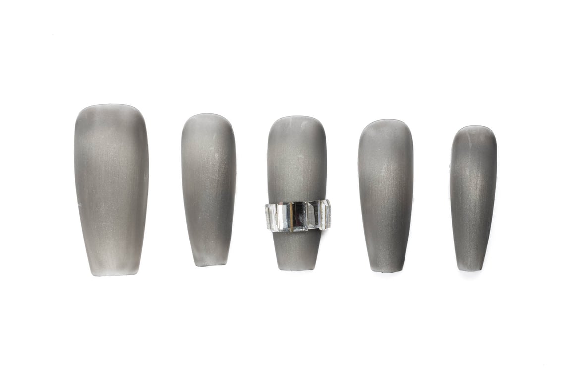 matte gunmetal gray coffin press-on nails arranged in descending size, with crystal rhinestone band accent on center nail