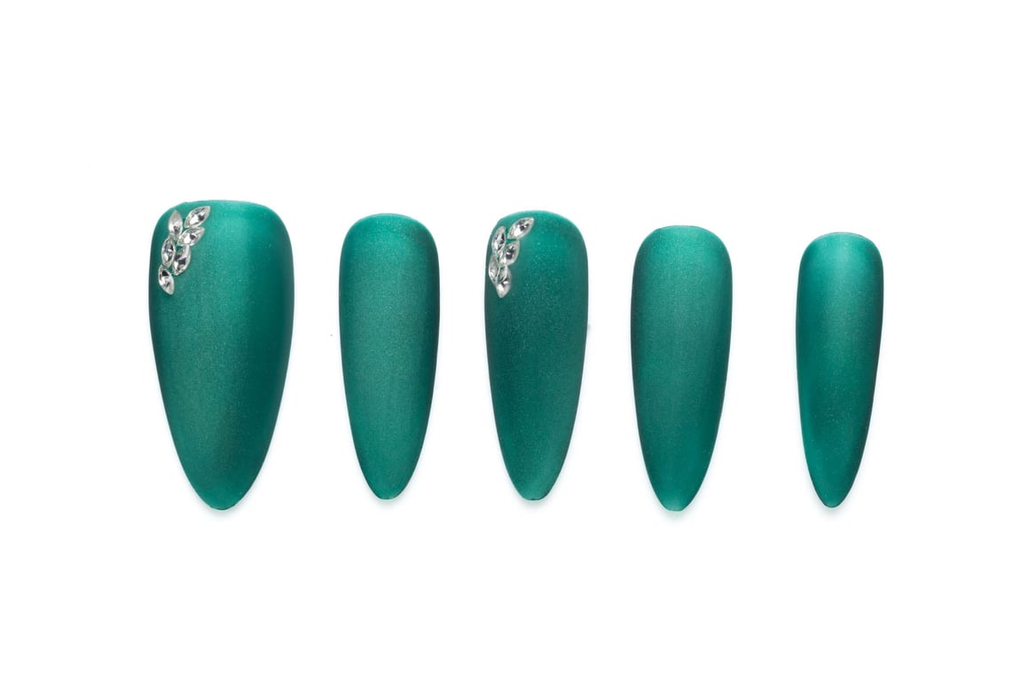 Emerald green medium-length almond press-on nails with rhinestone accents and shimmer finish