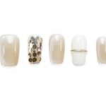 Short squoval press-on nails in nude with gold glitter and metallic band accent, perfect for everyday elegance