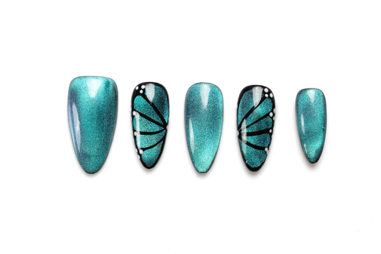 Shimmering teal almond-shaped press-on nails with black butterfly wing accents