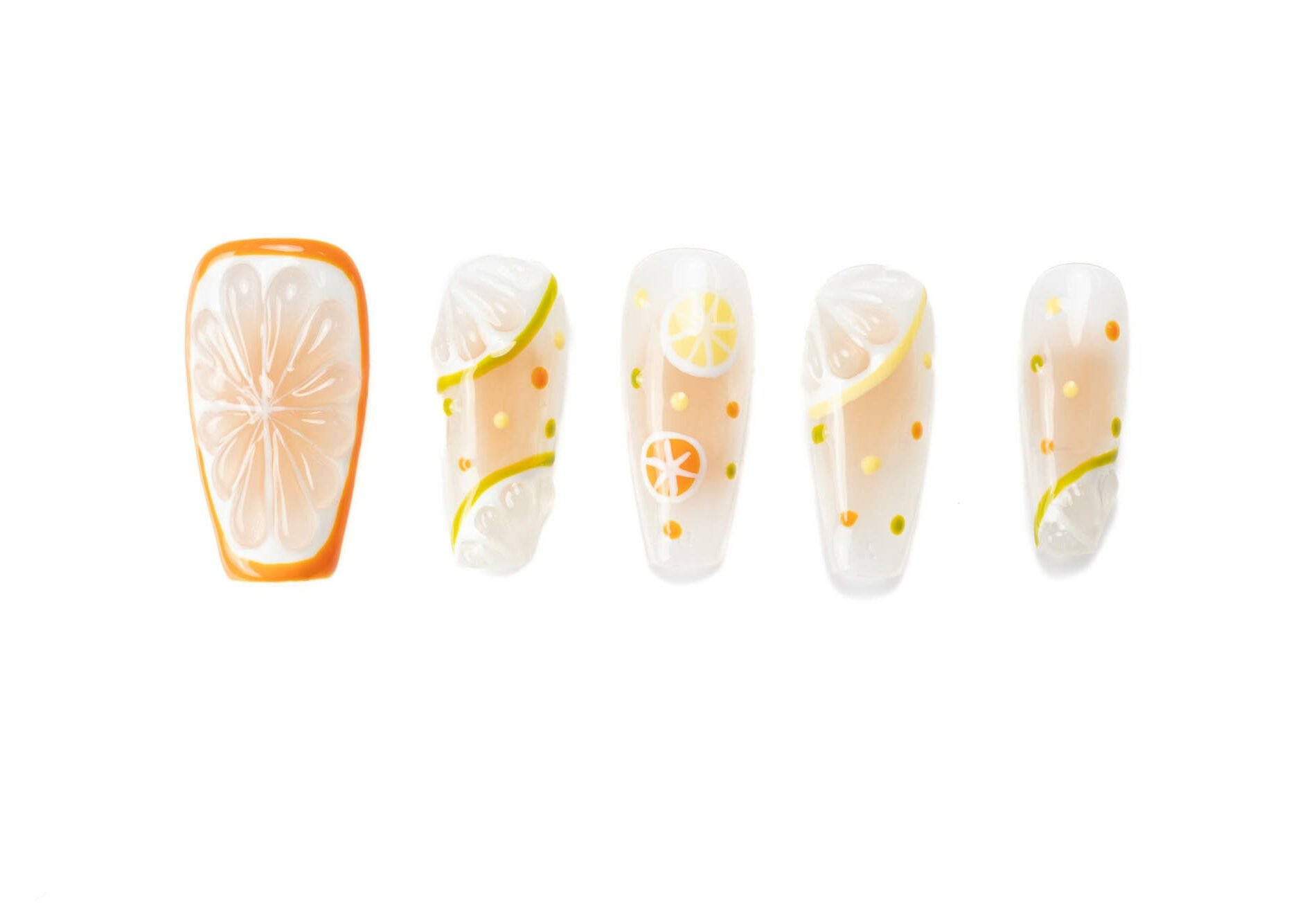 Coffin-shaped press-on nails featuring colorful citrus fruit designs with orange slices, lemons, and limes on a transparent base