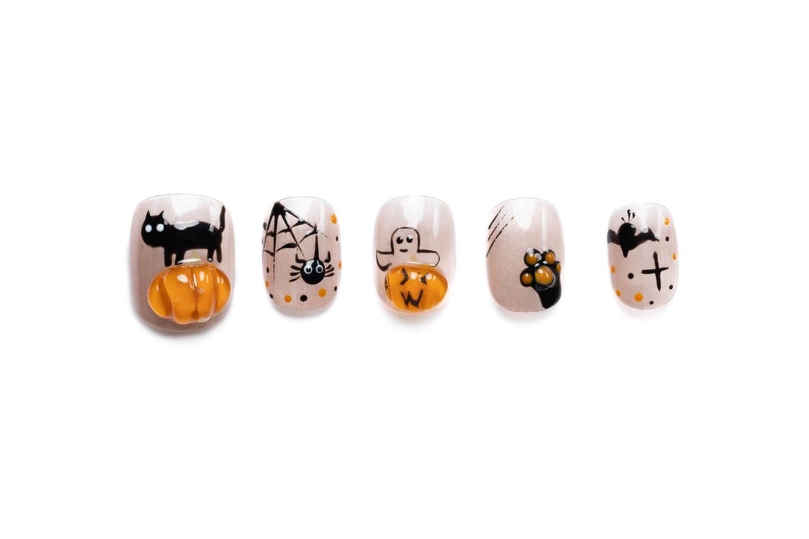 Short round Halloween press-on nails with cute spooky designs including black cats, pumpkins, ghosts, and bats on neutral base