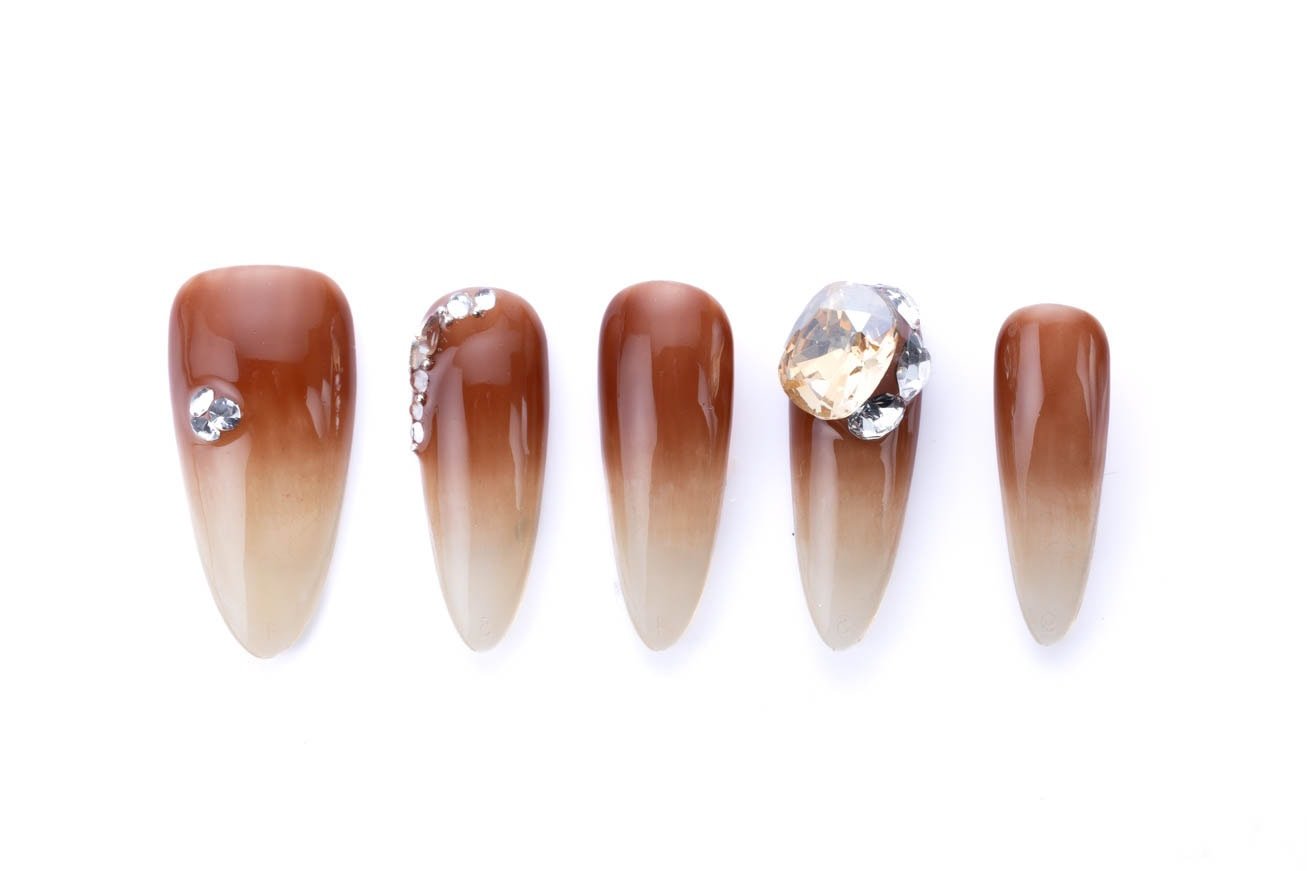 Brown ombre almond-shaped press-on nails with crystal accents and a glossy finish