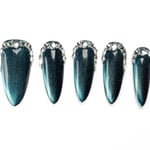 Dark teal stiletto press-on nails with shimmering cat eye effect and crystal border detail, showing dramatic length and shine