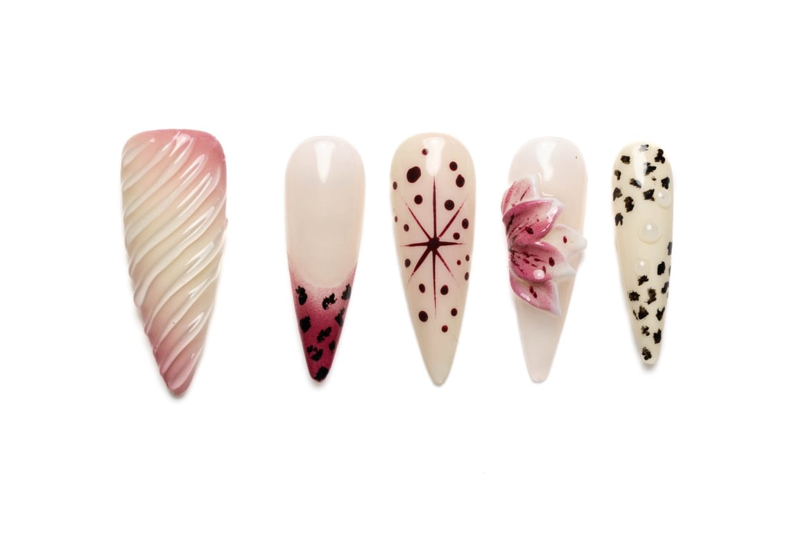 Stylish stiletto press-on nails with floral, leopard print, and abstract designs in pink, nude, and burgundy summer colors