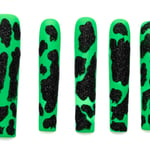 Extra long coffin press-on nails in bright green with sparkly black cow print pattern, arranged in descending size order