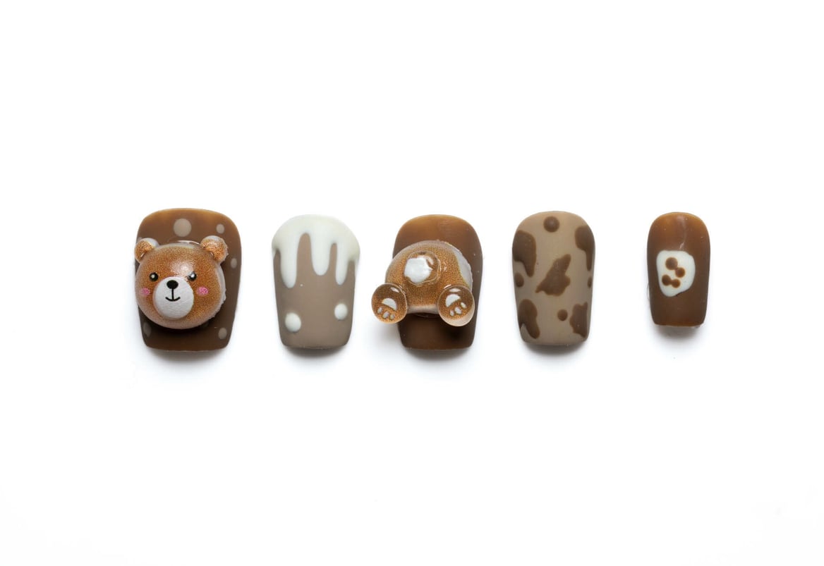 Short squoval press-on nails with cute teddy bear design, featuring 3D embellishments and chocolate drip accents