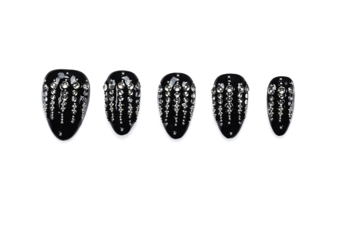 Set of five glossy black almond-shaped press-on nails decorated with vertical cascading rhinestone patterns on white background