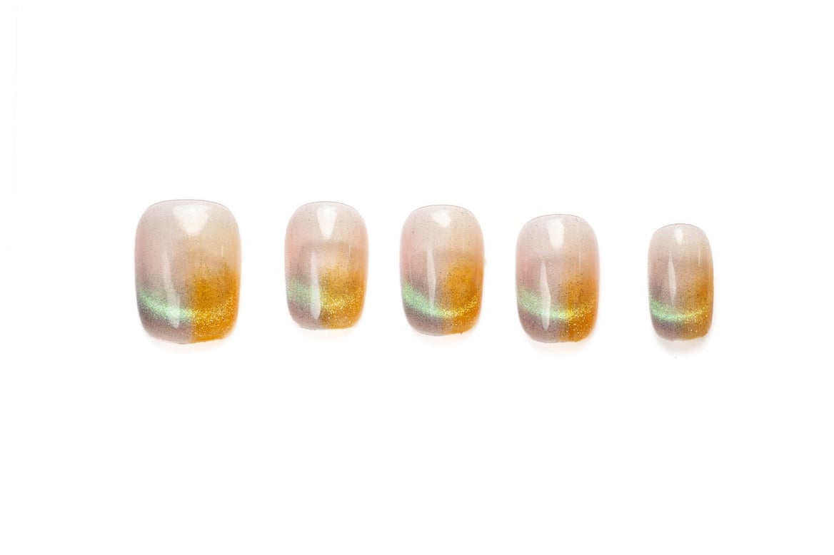 Short squoval press-on nails with shimmering cat eye effect in warm golden tones, perfect for everyday wear